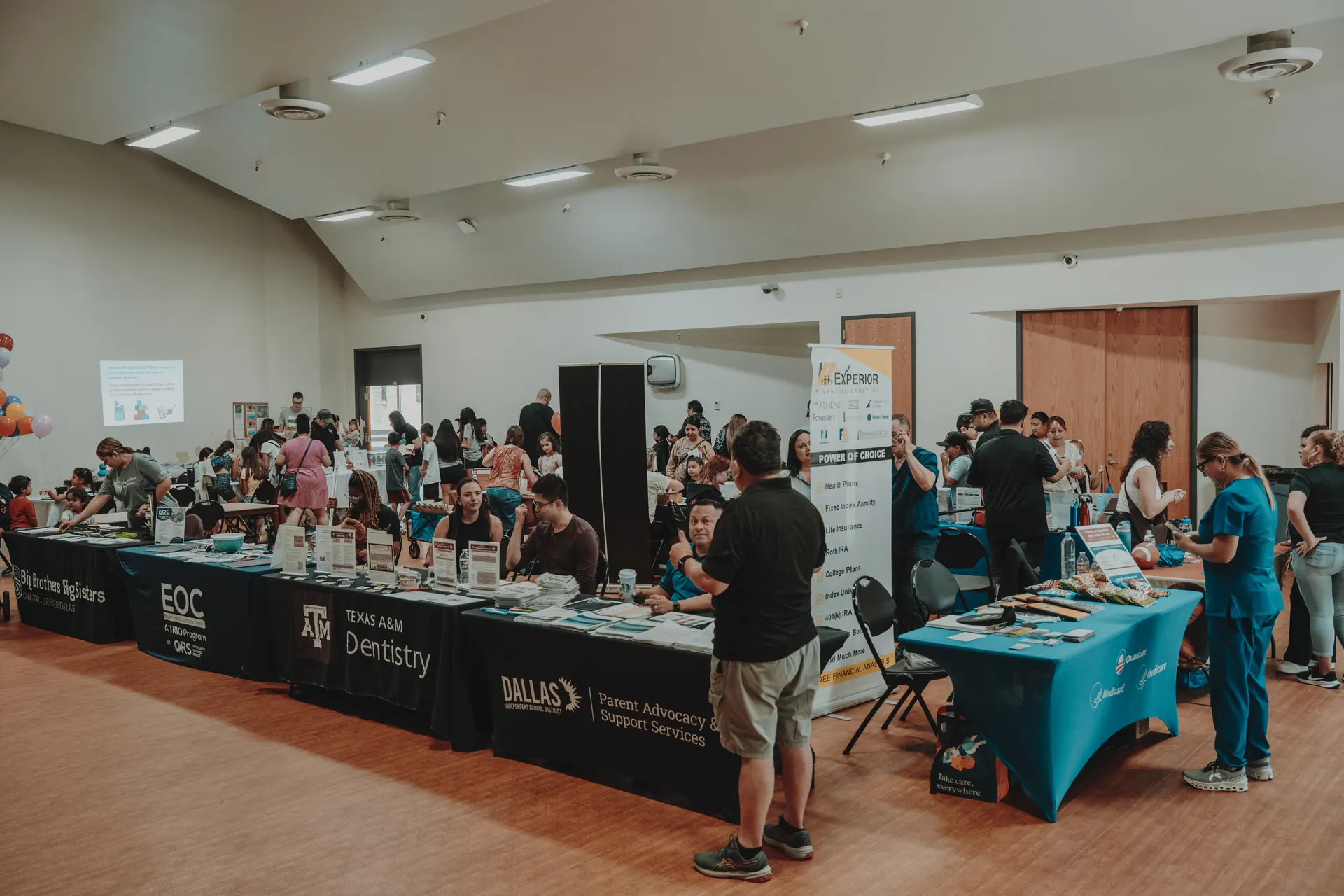 A full room of resource tables and families at Community Day
