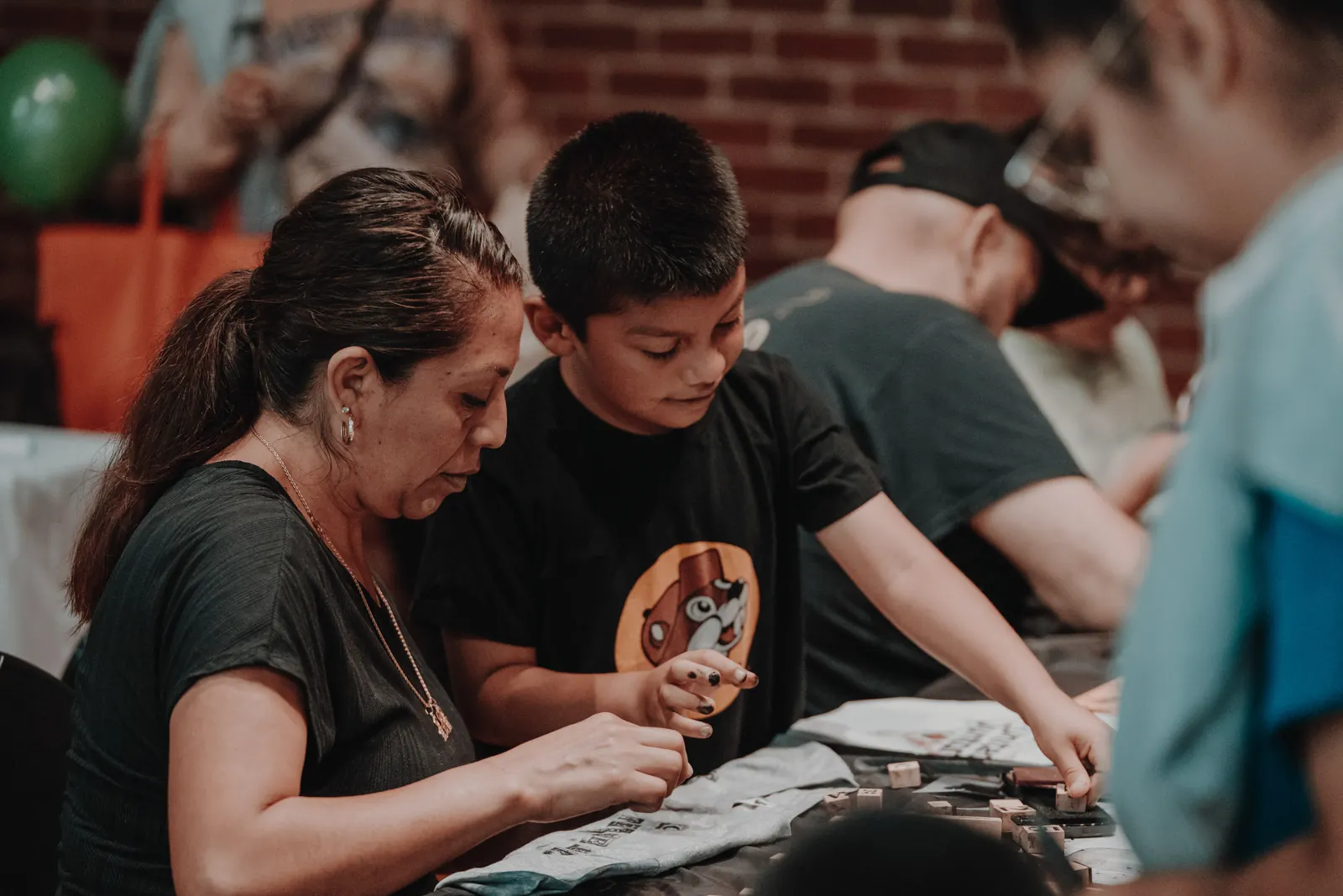 A mother and son stamping designs onto a shirt at Community Day